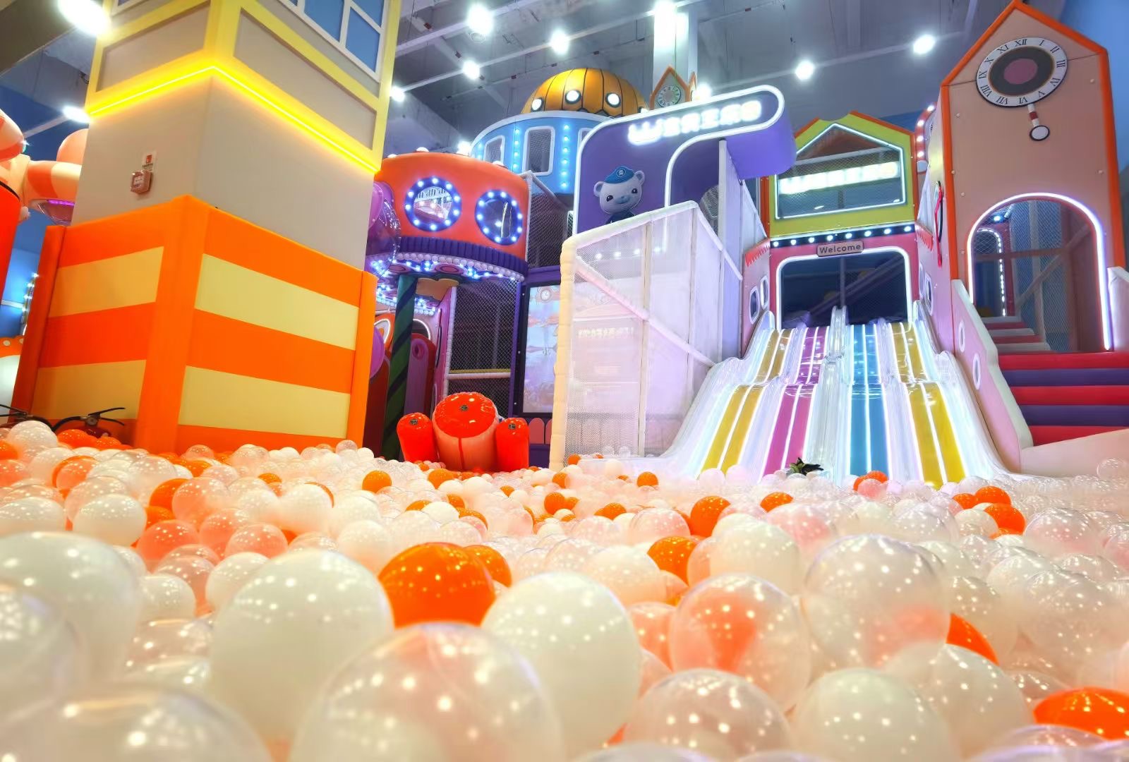 Wejście na kryty plac zabaw ze zjeżdżalnią z motywem kresk&oacute;wek