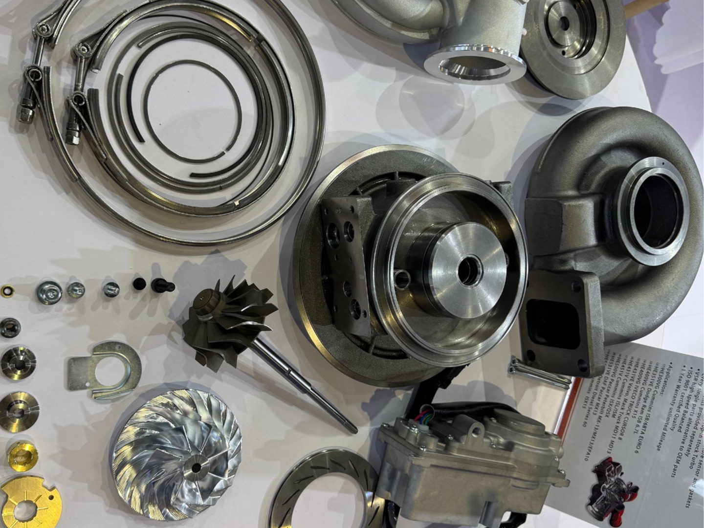 zesp&oacute;ł turbosprężarki ze zdemontowanymi częściami na białym materiale